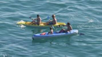 Un grupo de personas haciendo kayak en aguas tranquilas.