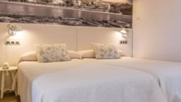 Un dormitorio con dos camas, una mesita de noche y un estante en la pared.