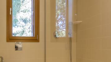 Un baño con inodoro, ducha y bañera.