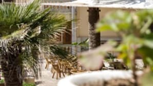 Een hotel met meerdere verdiepingen, balkons en palmbomen.