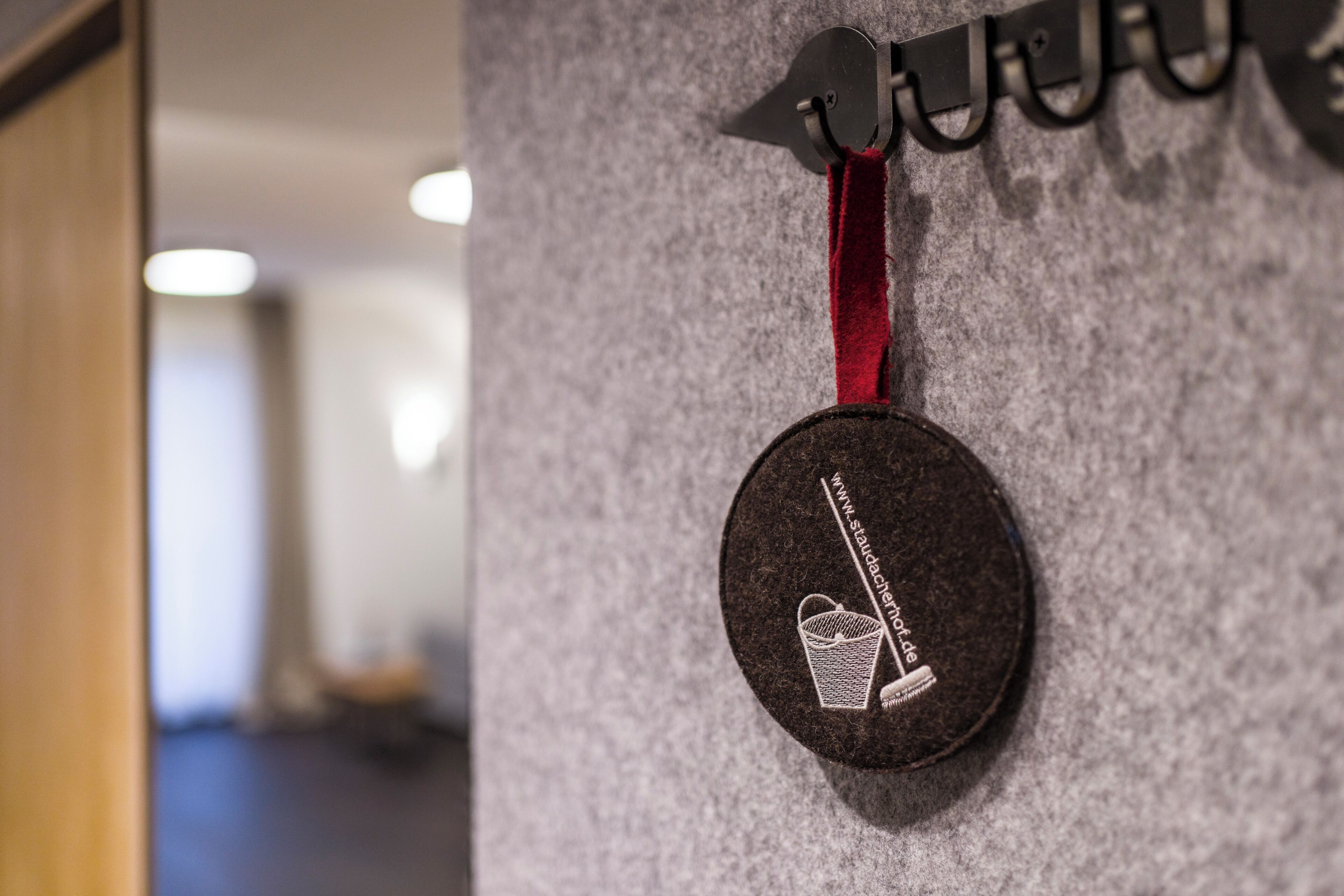 A circular badge with a website URL and a graphic of a bucket on a wall.
