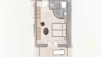 Un plan d’étage d’une chambre d’hôtel comprenant un lit, un bureau, une chaise, une petite table et une salle de bain.