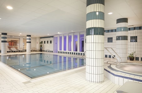 Una piscina techada, sillones reclinables de piscina