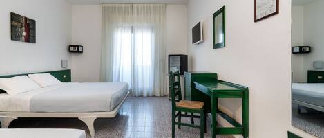 A hotel room with two beds, a desk, a chair, a mirror, and a window with curtains.