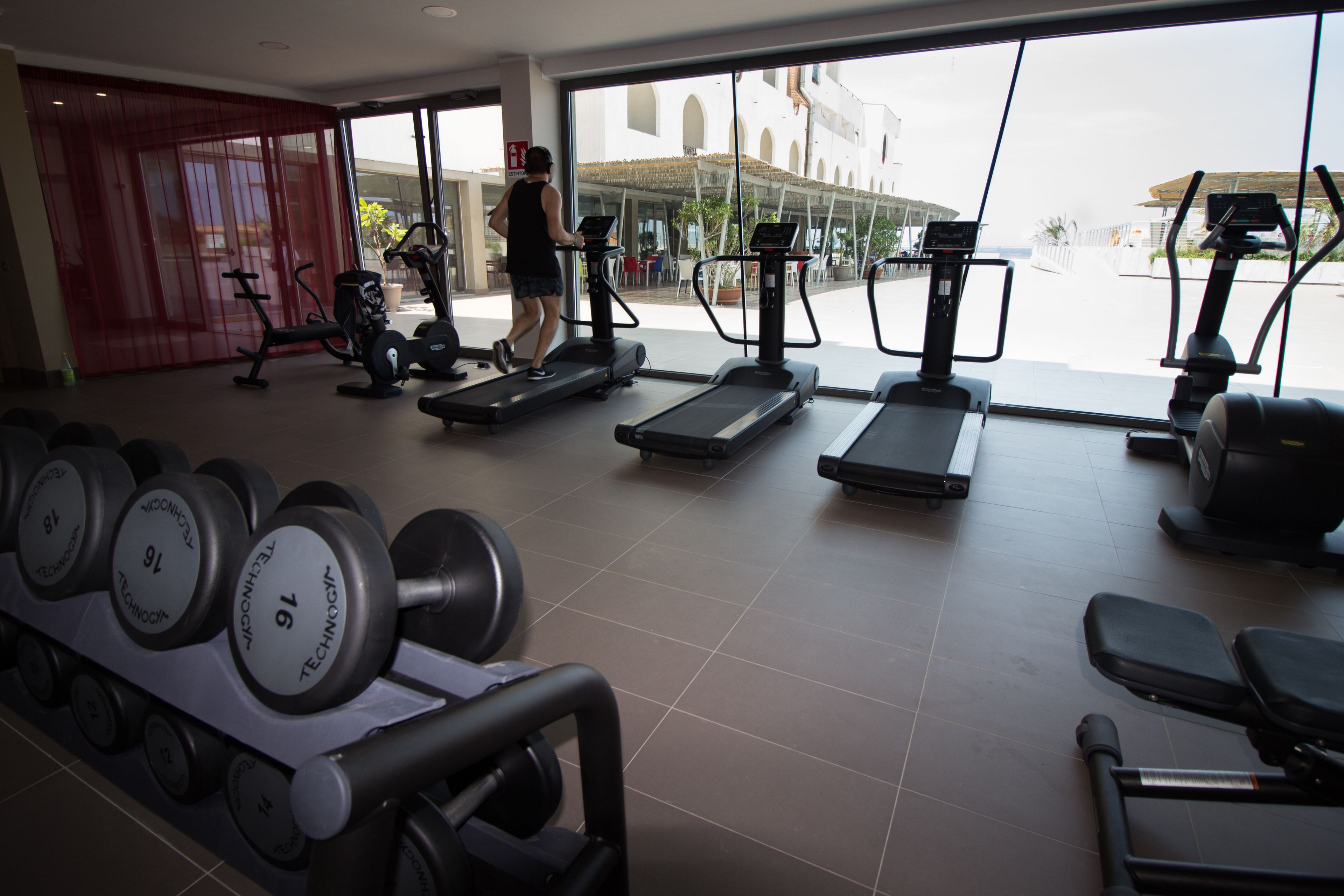 A gym with treadmills, dumbbells, and exercise equipment.