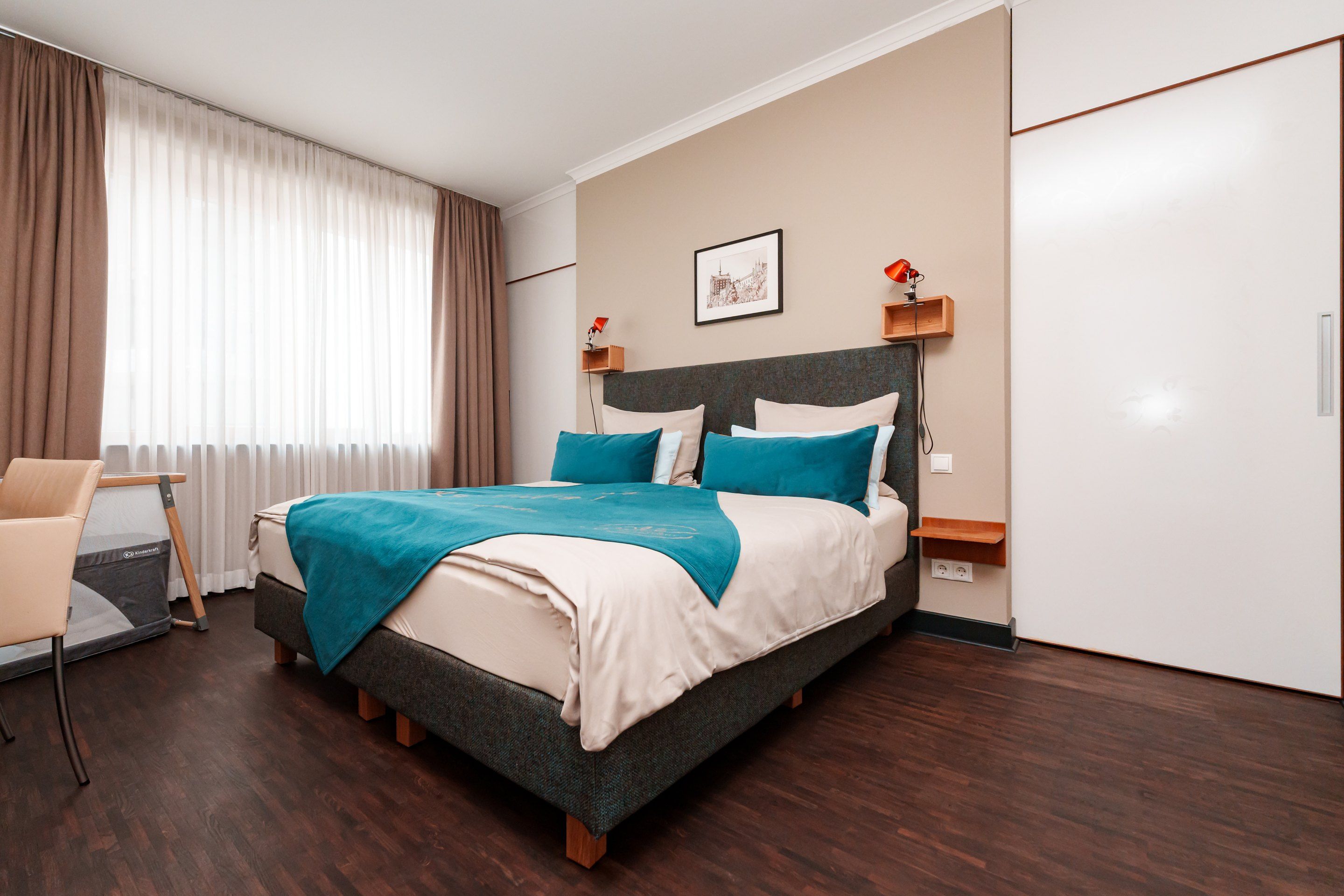 Ein Hotelzimmer mit Bett, Schreibtisch, Stuhl und Kleiderschrank.