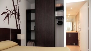 A modern bedroom with a bed, a wardrobe, and a bathroom visible through an open door. - Residence Calypso (Marseille)