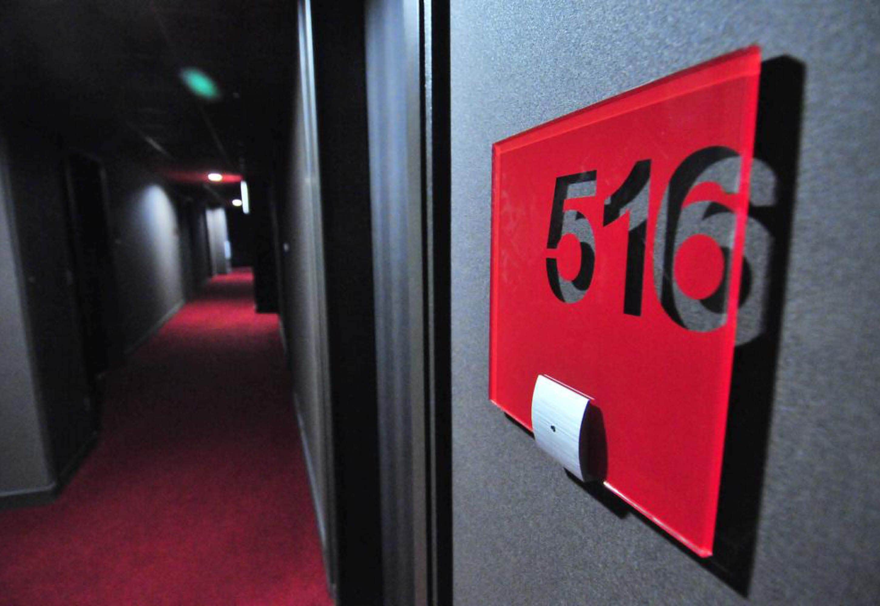 Een gang met een rood bord waarop kamer 516 staat.