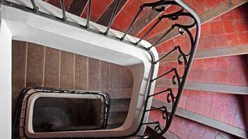 Una escalera de caracol con barandilla de metal y pasamanos blanco.