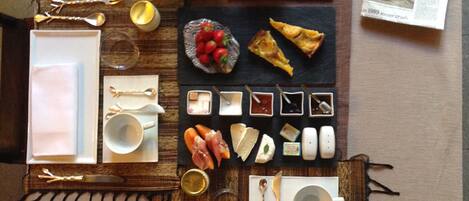 A table set with various food items, utensils, and a newspaper.