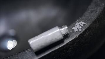 A close-up of a metallic object with a white substance on it.