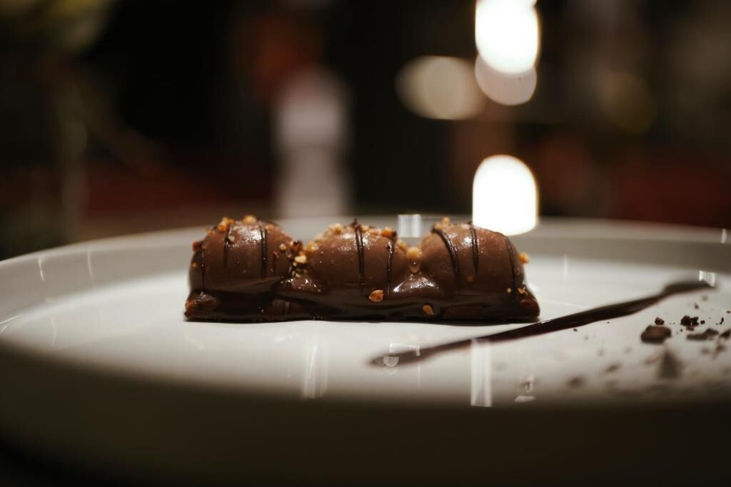 Un dessert au chocolat sur une assiette blanche, avec une fourchette à côté.