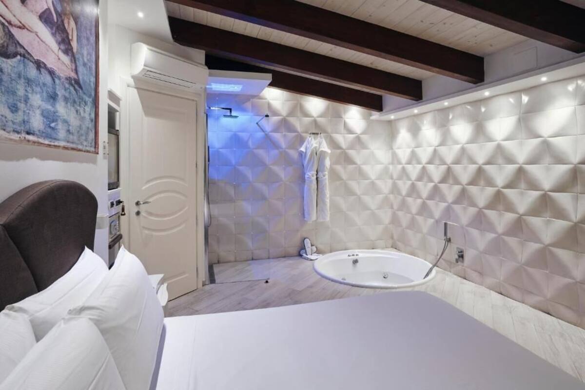 Un bagno moderno con una vasca da bagno spaziosa, una doccia e un mobile lavabo bianco.