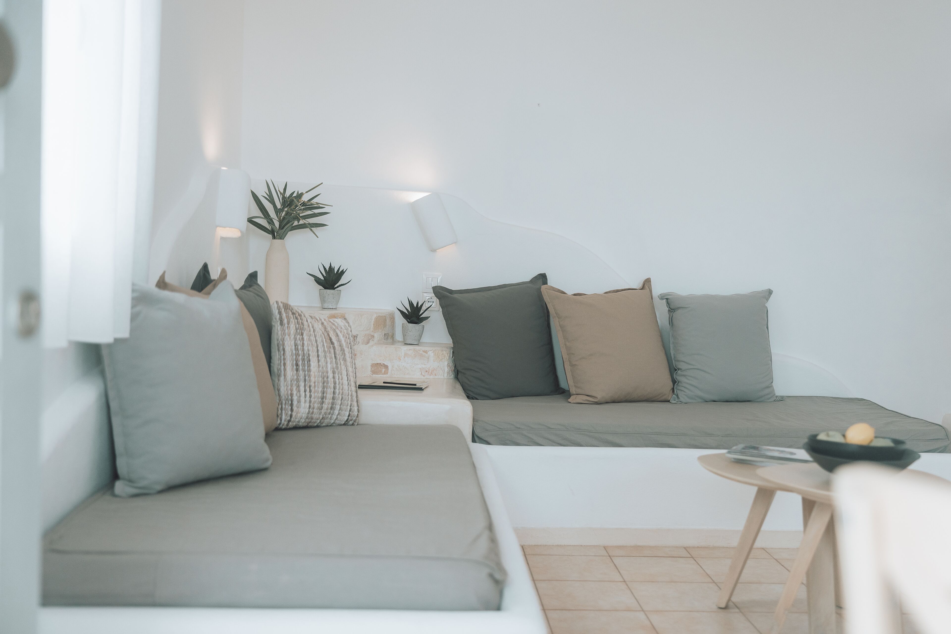 A modern living room with a sofa, a small table, and a lamp.