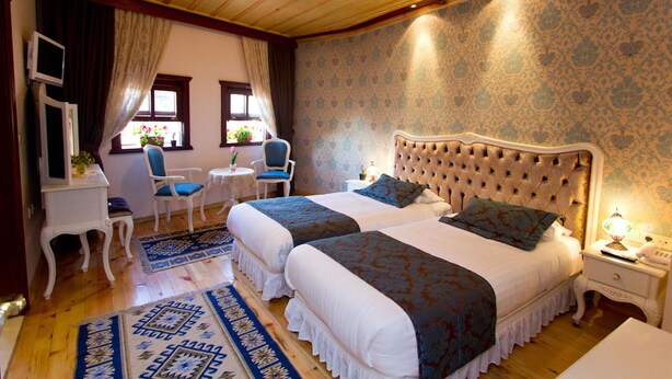A hotel room with two beds, a sitting area with chairs, a small table, and a desk. - Esans Hotel - Special Class (Istanbul)