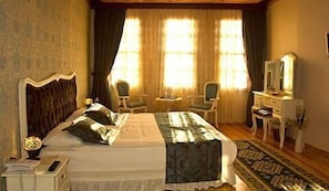 A hotel room with a large bed, two chairs, a small table, a dresser, and a mirror. - Esans Hotel - Special Class (Istanbul)