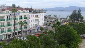 Un hotel llamado 'Hotel Yeniceri' con varios pisos, balcones y vista al mar.