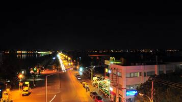 A nighttime street view with cars, streetlights, and buildings.