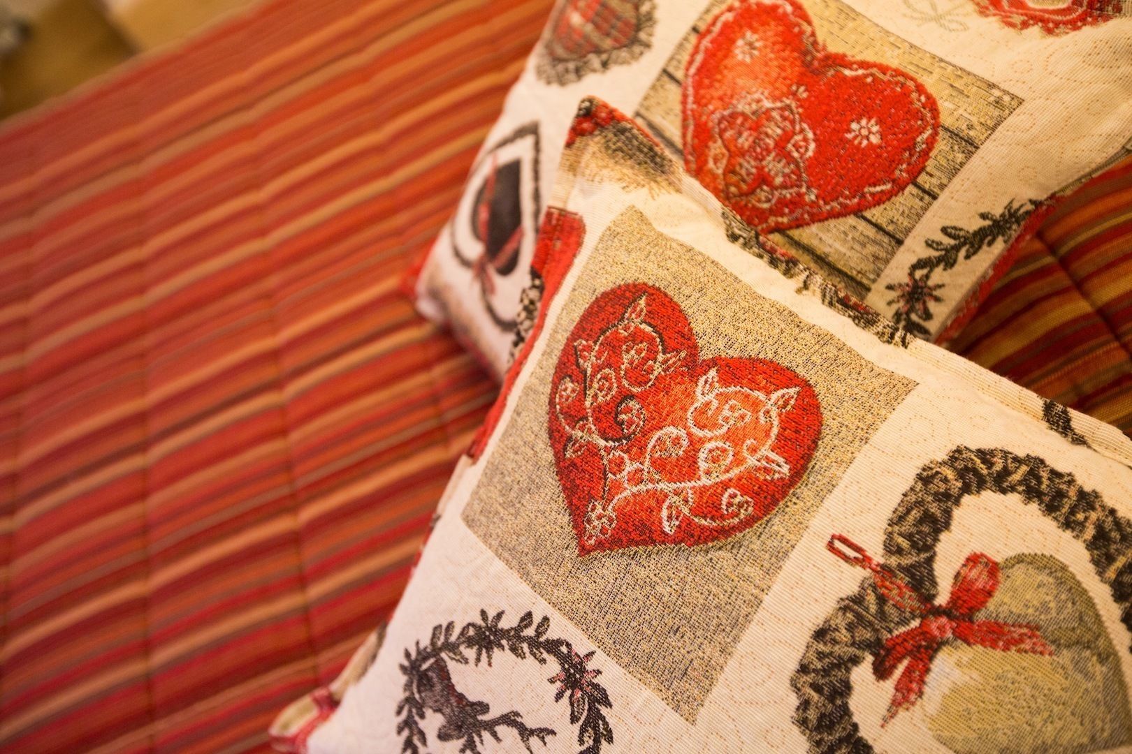 A close-up of a bed with a striped red and beige bedspread.