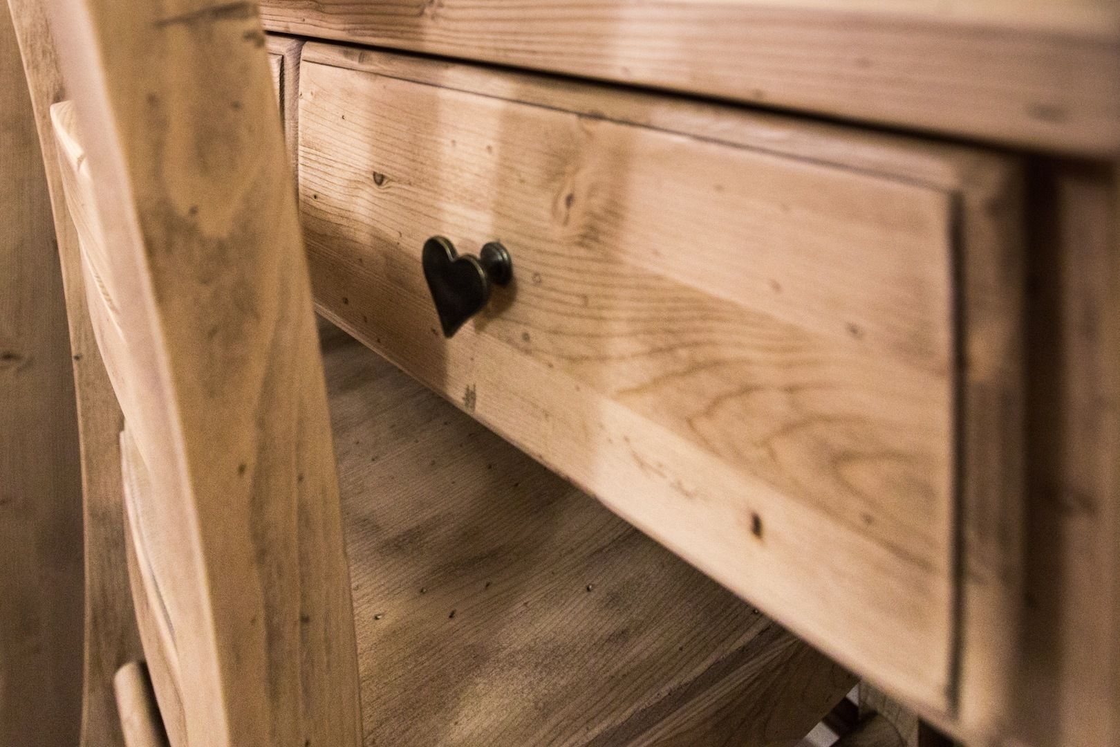 A wooden drawer with a heart-shaped handle.
