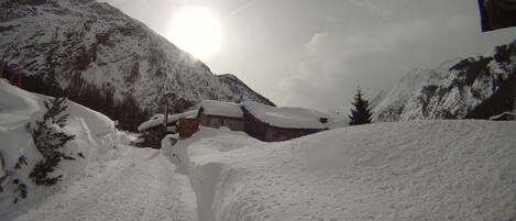 Un paisaje montañoso cubierto de nieve, con un edificio parcialmente oculto por la nieve.