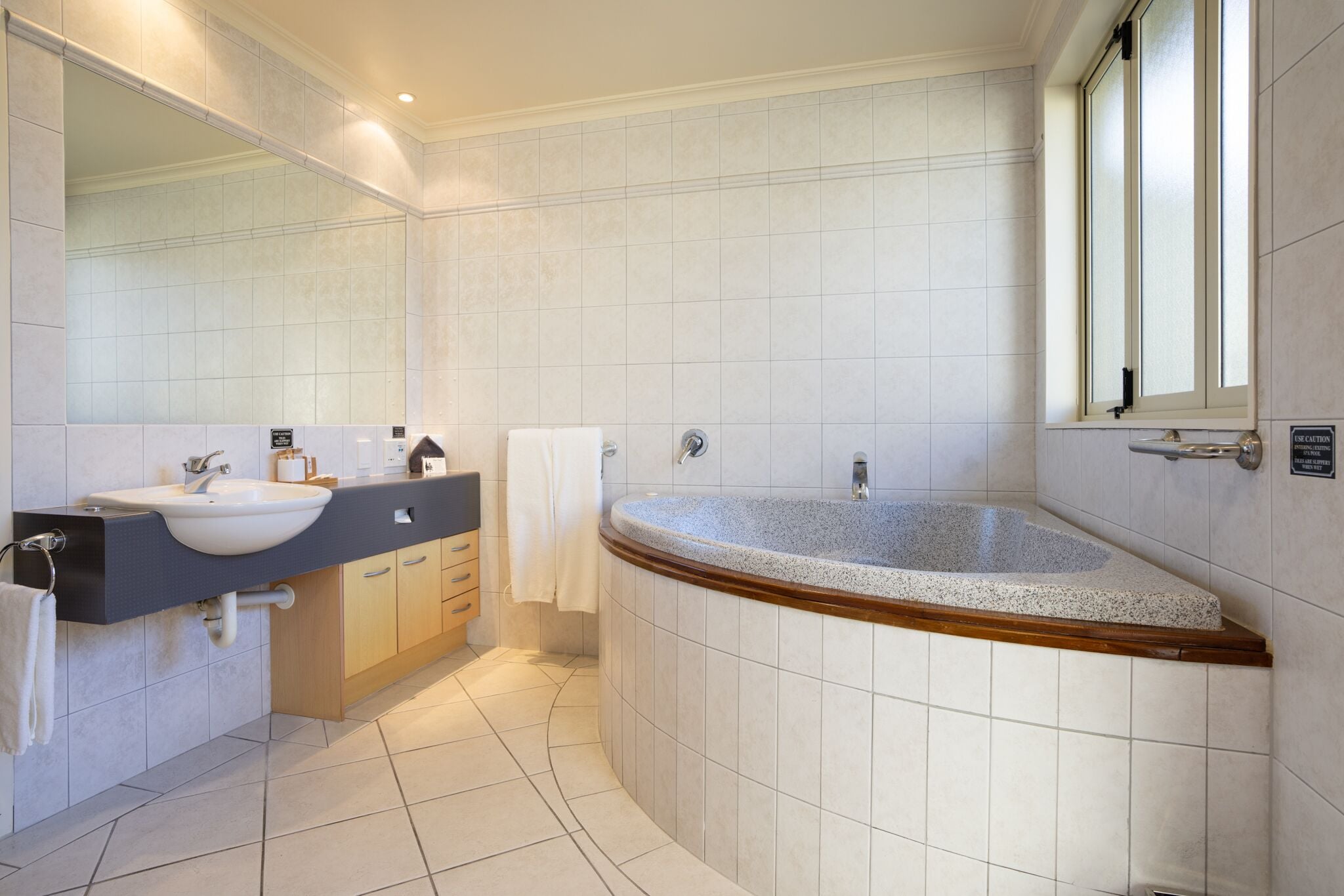 Een moderne badkamer met een vrijstaand bad, een wastafel en een badkamerkast.