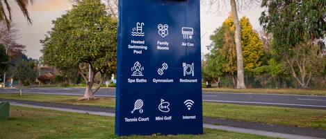 A sign for Regal Palms Resort with amenities like a heated swimming pool, family rooms, air conditioning, spa baths, a gymnasium, a restaurant, a tennis court, a mini-golf course, and internet access.
