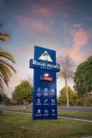 Placa do Regal Palms Resort com comodidades como piscina aquecida, quartos familiares, ar condicionado, banheiras de hidromassagem, academia, restaurante, quadra de tênis, campo de mini golfe e acesso à internet.