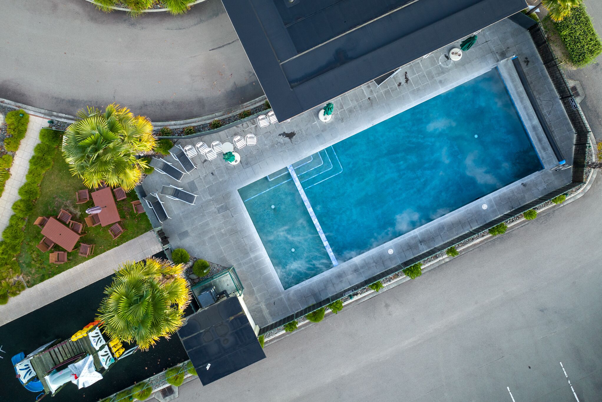 Een buitenzwembad, parasols voor strand/zwembad