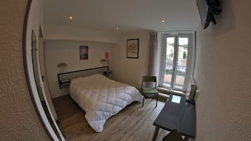 A room with a bed, a desk, a chair, a window, and a picture on the wall.