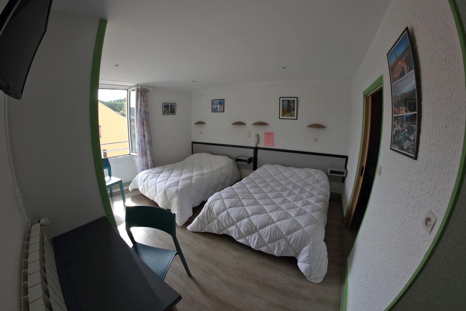 Una habitación con dos camas, un escritorio y una silla.