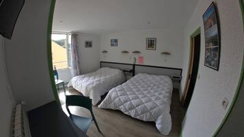 Una habitación con dos camas, un escritorio y una silla.