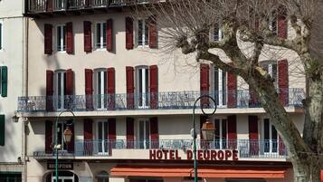 Ein Hotel mit einer Rezeption, Außenbereich und einem Schild mit der Aufschrift 'HOTEL DE EUROPE'.