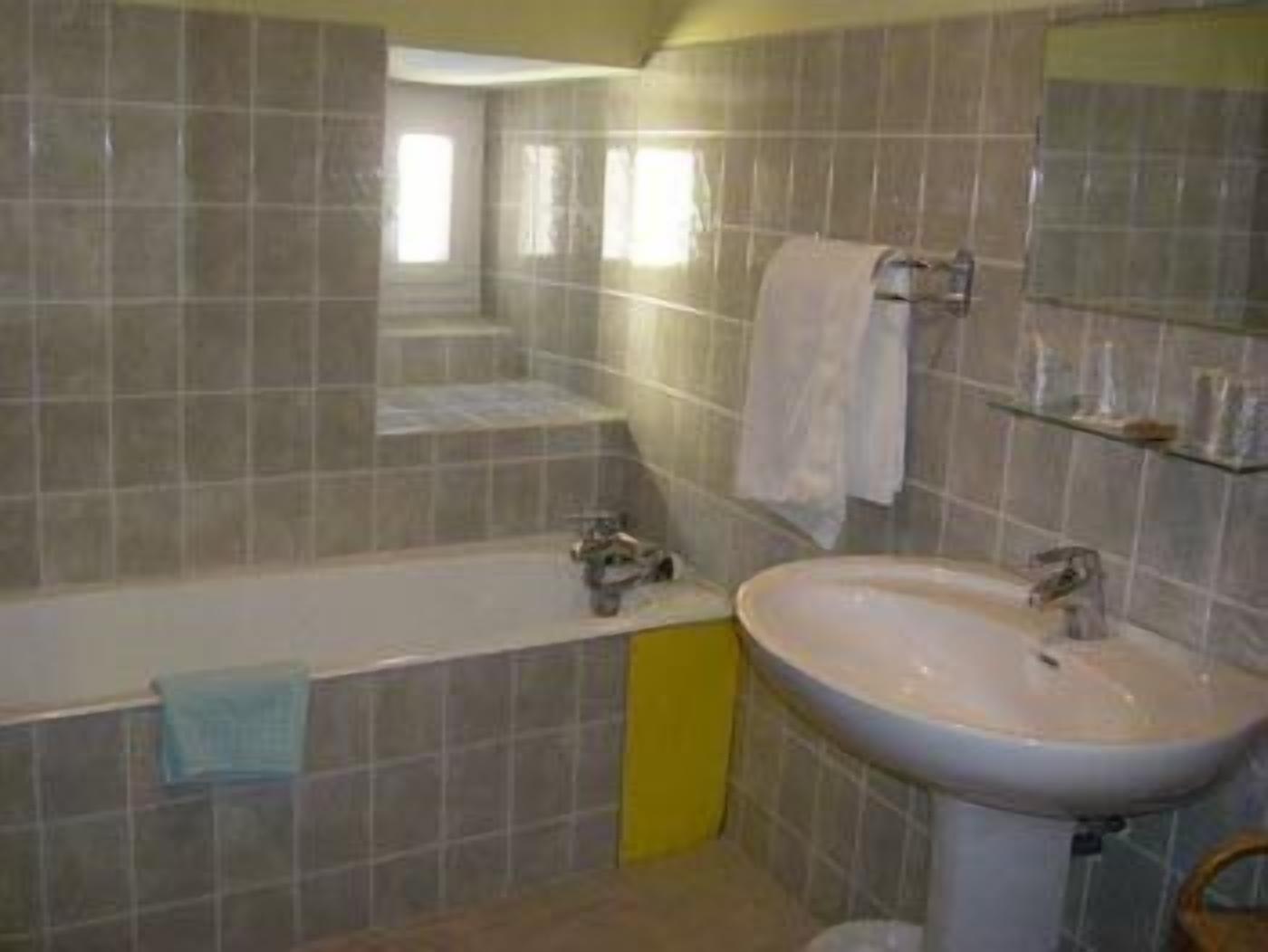 Un baño con una bañera, un lavamanos y un espejo.
