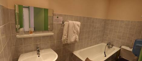Un baño con lavamanos, bañera y retrete.