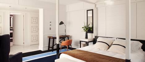A modern bedroom with a four-poster bed, a desk, and a chair.