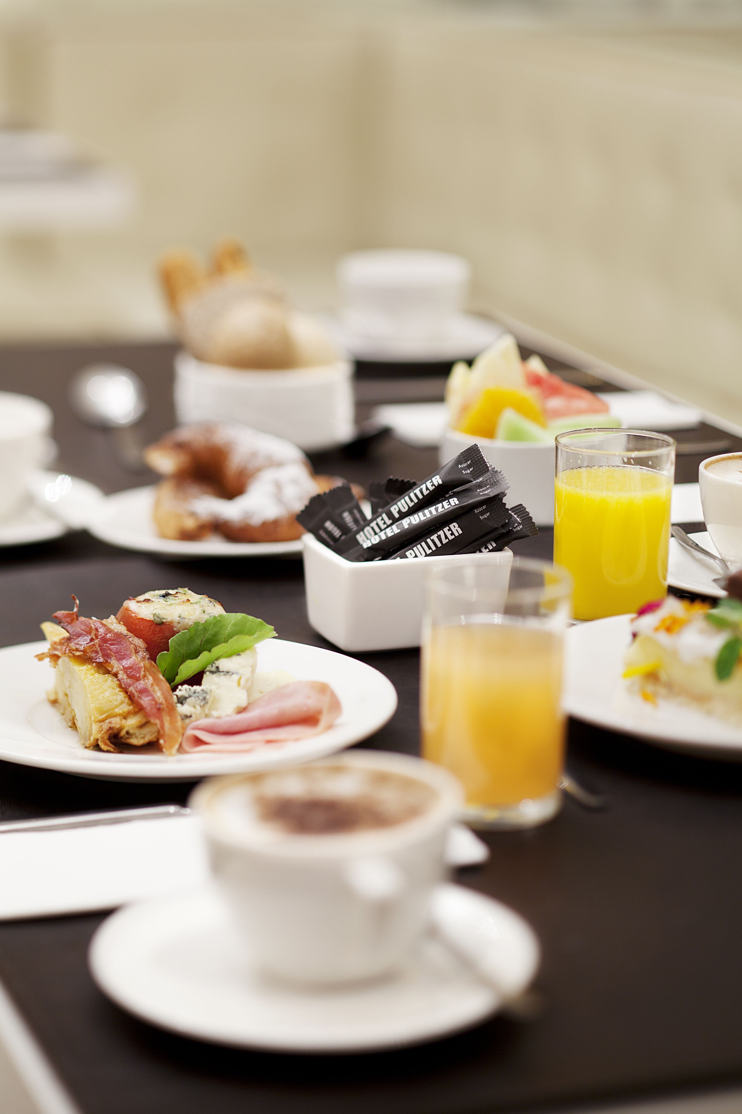 Desayuno con platos de comida, una taza de café y un vaso de zumo de naranja.