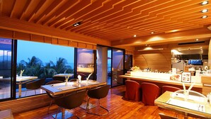 Eine moderne Küche mit Holzboden, einer Bar und großen Fenstern mit Blick ins Freie.
