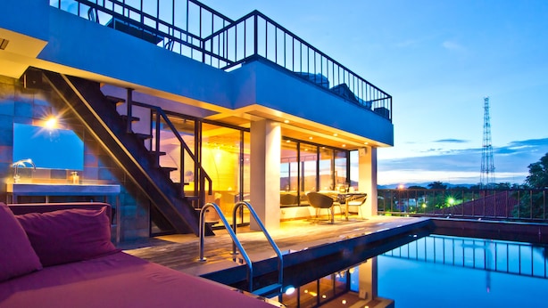 Ein modernes Hotel mit Pool, Balkon und Essbereich.