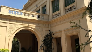 A classical building with a central archway, symmetrical windows, and decorative balustrades. - WelcomHeritage Sheikhpura Kothi (Hansi)