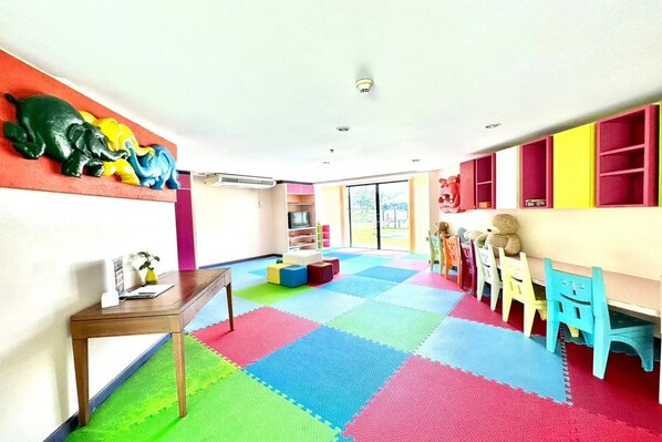 A brightly colored playroom with a colorful floor, a wooden table, and a wall-mounted elephant sculpture. - Laguna Holiday Club Phuket Resort (Choeng Thale)