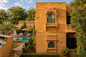 Un bâtiment traditionnel doté d’une piscine, d’un espace extérieur aménagé et d’une végétation luxuriante.