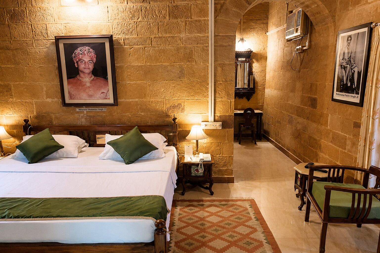 A hotel room with a bed, bedside tables, a desk, and a chair.