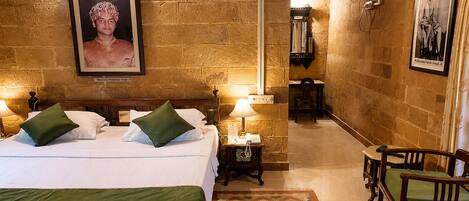 Una habitación de hotel con cama, mesitas de noche, un escritorio y una silla.