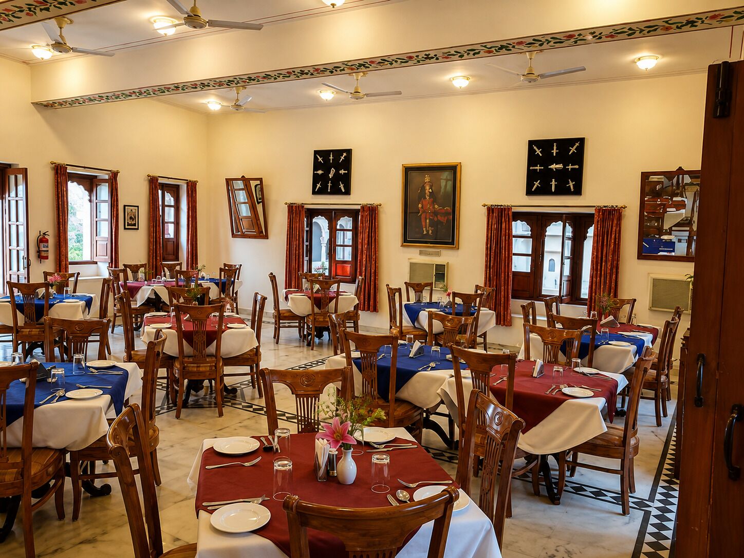 Comedor con varias mesas, sillas y ventiladores de techo.