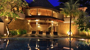 A resort with a swimming pool, lounge chairs, and a covered outdoor area with a thatched roof. - Abi Bali Resort Villas & Spa (Jimbaran)