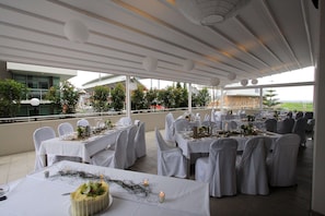 Enjoy dining in style with round tables set amidst a modern architecture with a flat roof and expansive views.