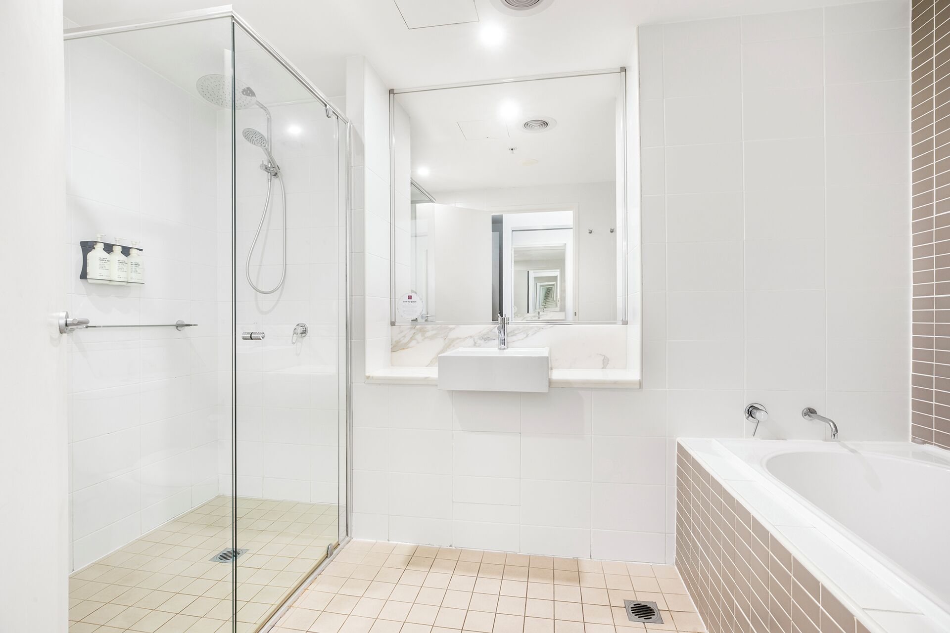 A modern bathroom with a glass-enclosed shower, a vanity with a sink, and a bathtub.