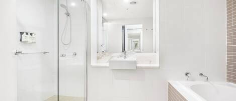 A modern bathroom with a glass-enclosed shower, a vanity with a sink, and a bathtub.