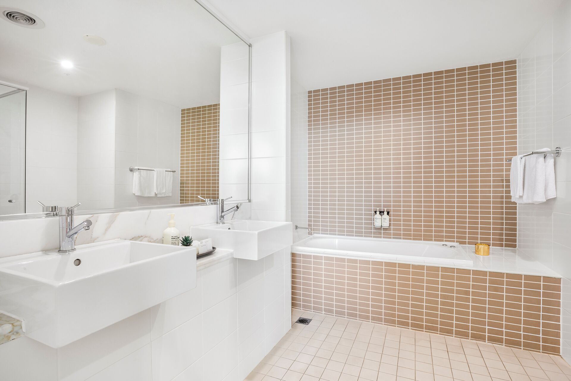 Ein modernes Badezimmer mit zwei Waschbecken, einer Badewanne und einer Dusche.